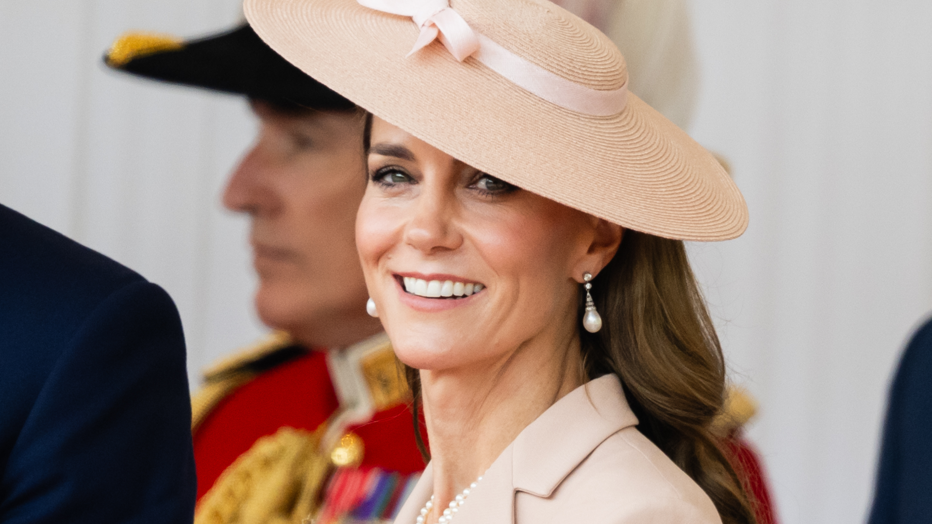 Princess Kate wearing a pink hat with a bow smiling