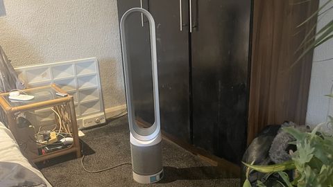 A Dyson air purifier next to cupboard