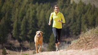 Woman running with her golden labrador