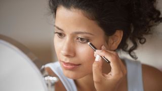 woman applying eye makeup