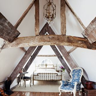 attic bedroom with wooden beams and flooring