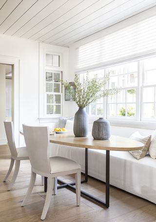 white kitchen with breakfast table and sofa by Marie Flanigan
