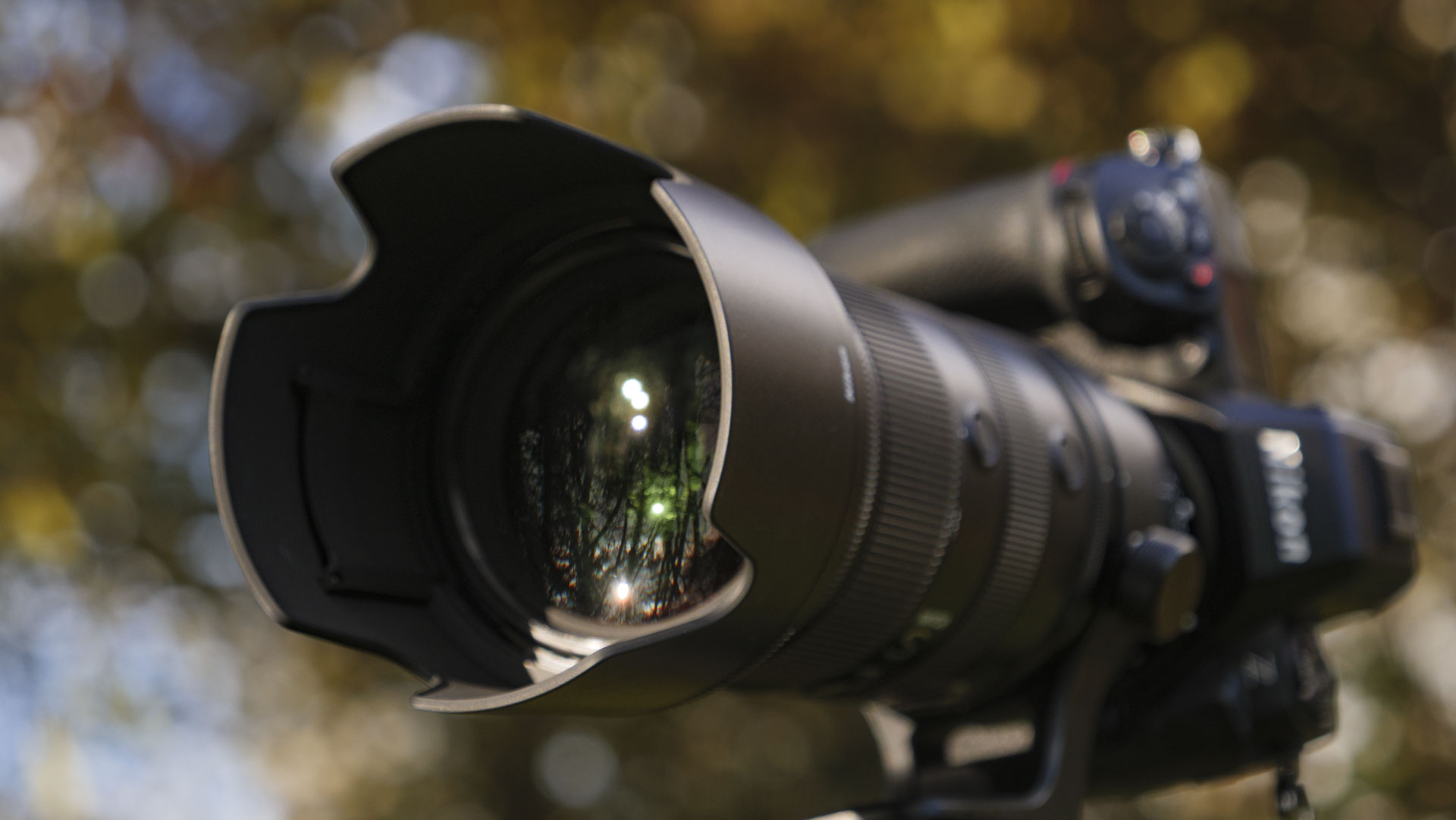 The Nikon Z 70-200mm f/2.8 VR S II lens attached to a Nikon Z8, the camera is mounted to a tripod and there are trees in the background