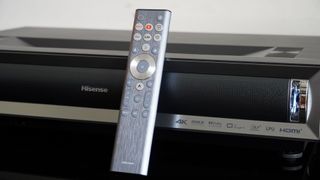 Hisense PX3-Pro UST projector on a table with remote control