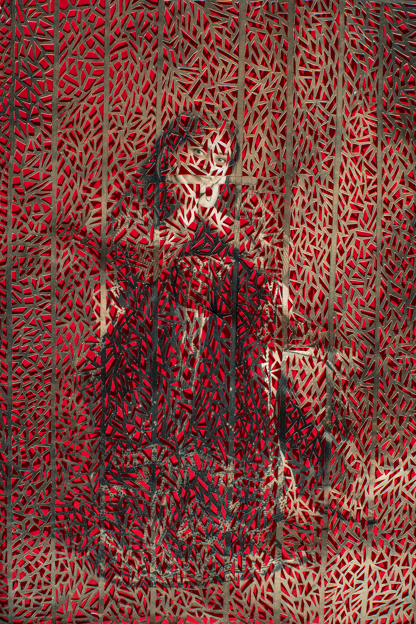 A woman sitting down in traditional attire, having her hands on her face, surrounded by intricate patterns 
