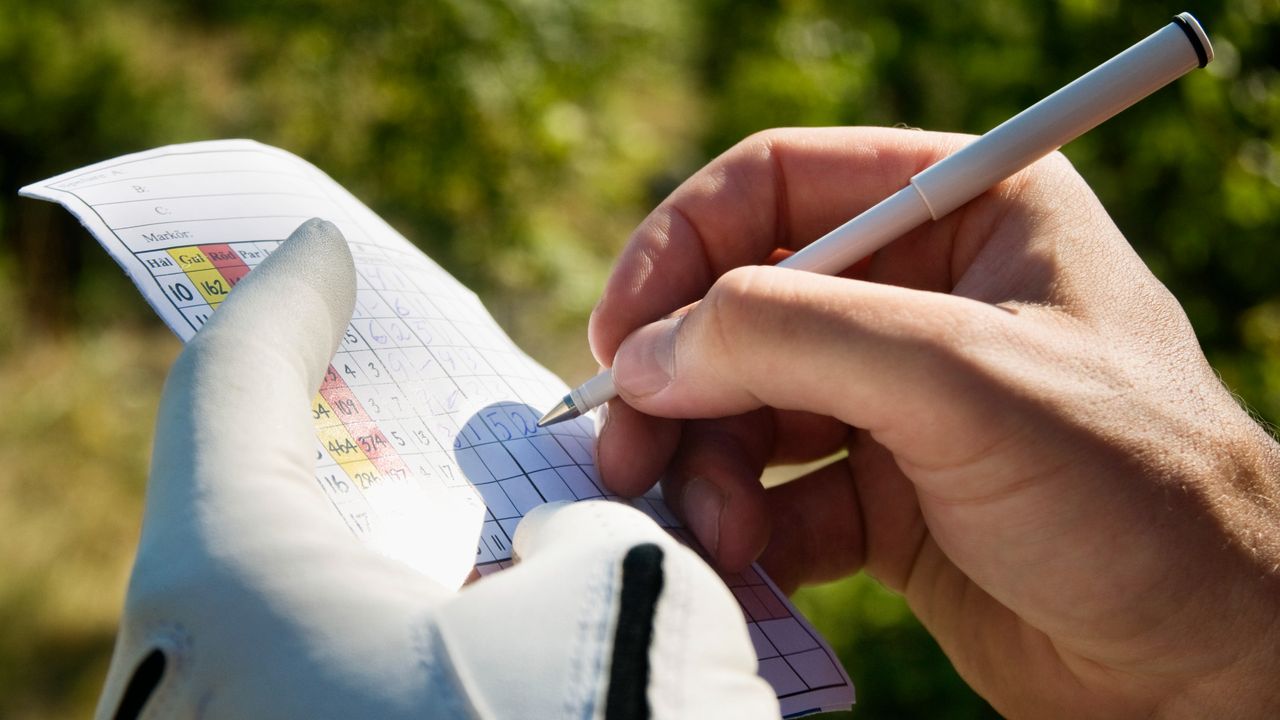 Close-up of a player marking a scorecard