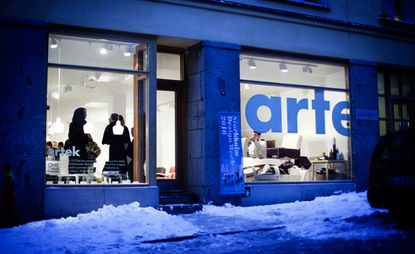 The exterior of Artek showroom in Stockholm with a view of people in showroom through the glass large glass windows