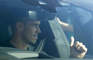 Gareth Bale gives a thumbs up to fans as he arrives at the training ground