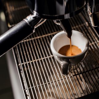 White ceramic espresso cup on bean to cup coffee machine