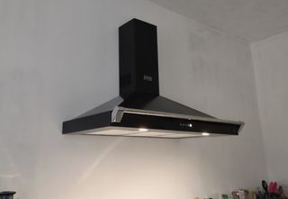 A black cooker hood on a white wall