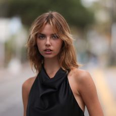 woman in black halterneck top with textured hair and minimal make-up