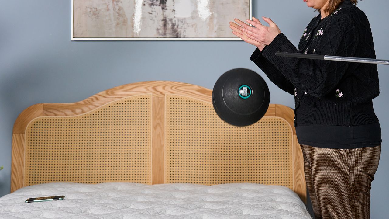 Tester Ruth Jones drops a slam ball on the Helix Sunset Luxe mattress to measure the motion isolation.