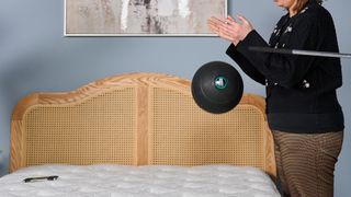 Tester Ruth Jones drops a slam ball on the Helix Sunset Luxe mattress to measure the motion isolation.