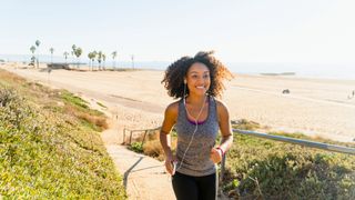 A woman runs by a beach