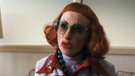 Amy Madigan as Aunt Gladys with a red wig and big sunglasses in Weapons