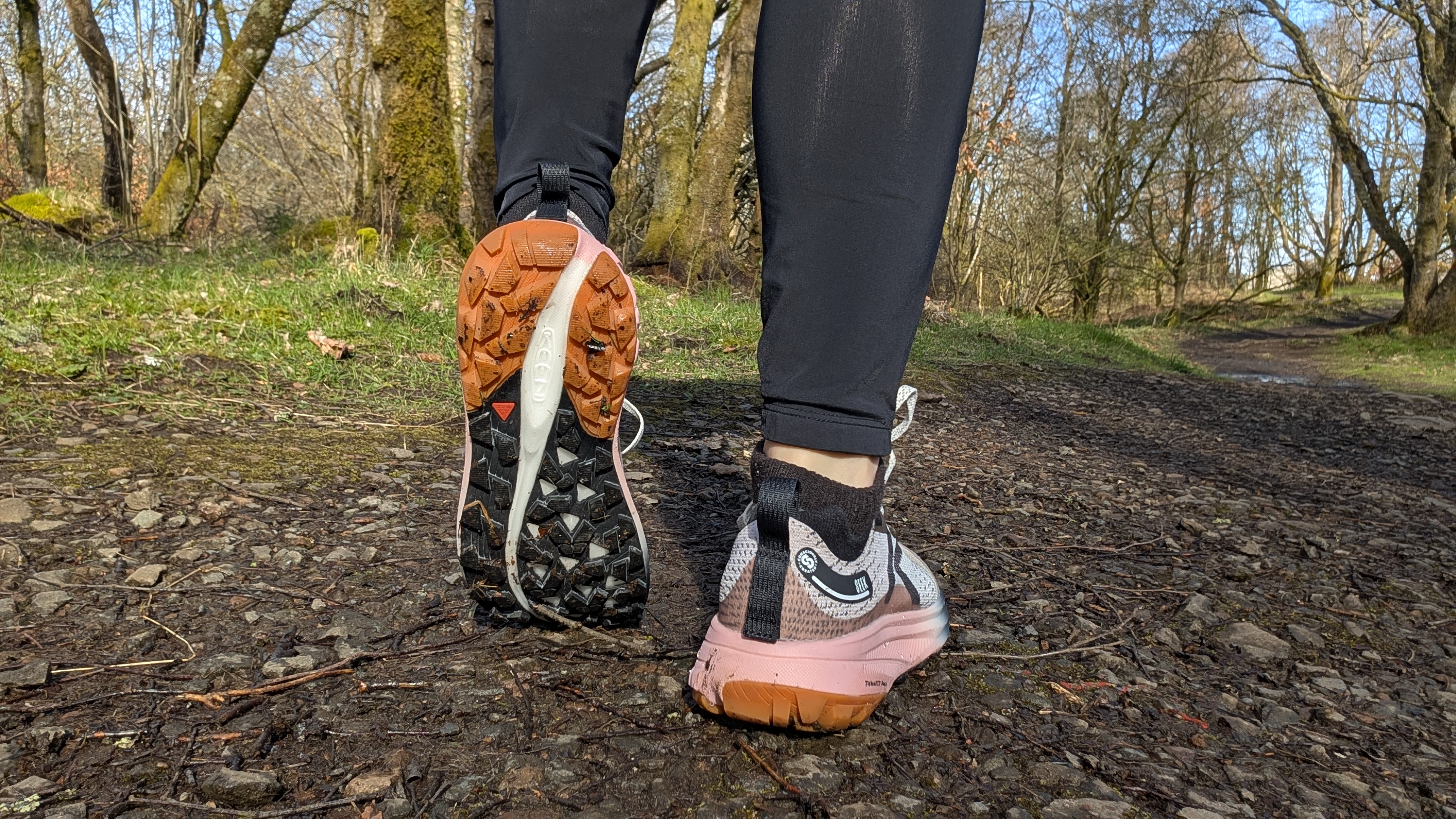 A runner's feet wearing the Keen Seek trail running shoes and showing the sole of one of the shoes