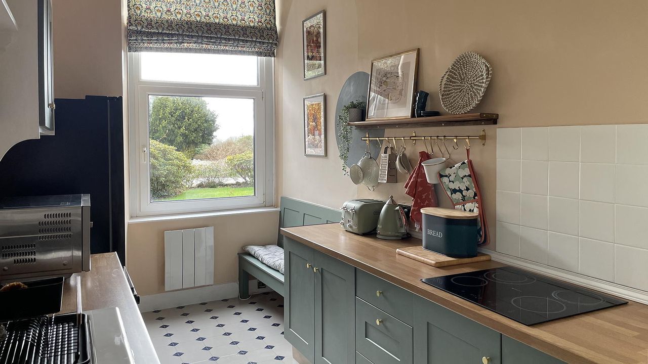 galley kitchen with green painted units and shelf