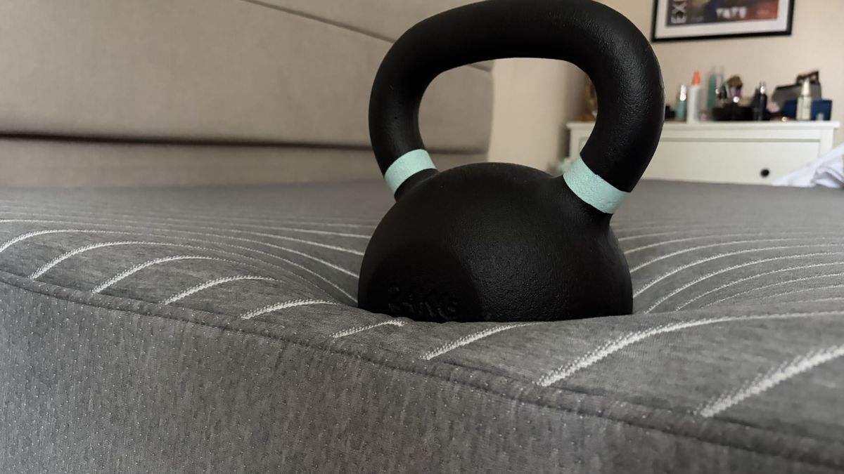 A close up of a 25lb weight balance on the edge of the Siena mattress in the home of our lead tester, Ruth Jones. While the weight doesn't sink that far into the mattress, it's made a clear impression in the foams