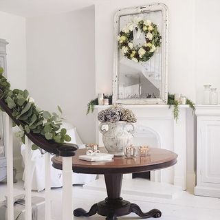 hallway with white wall and flower wreath with mirror on wall