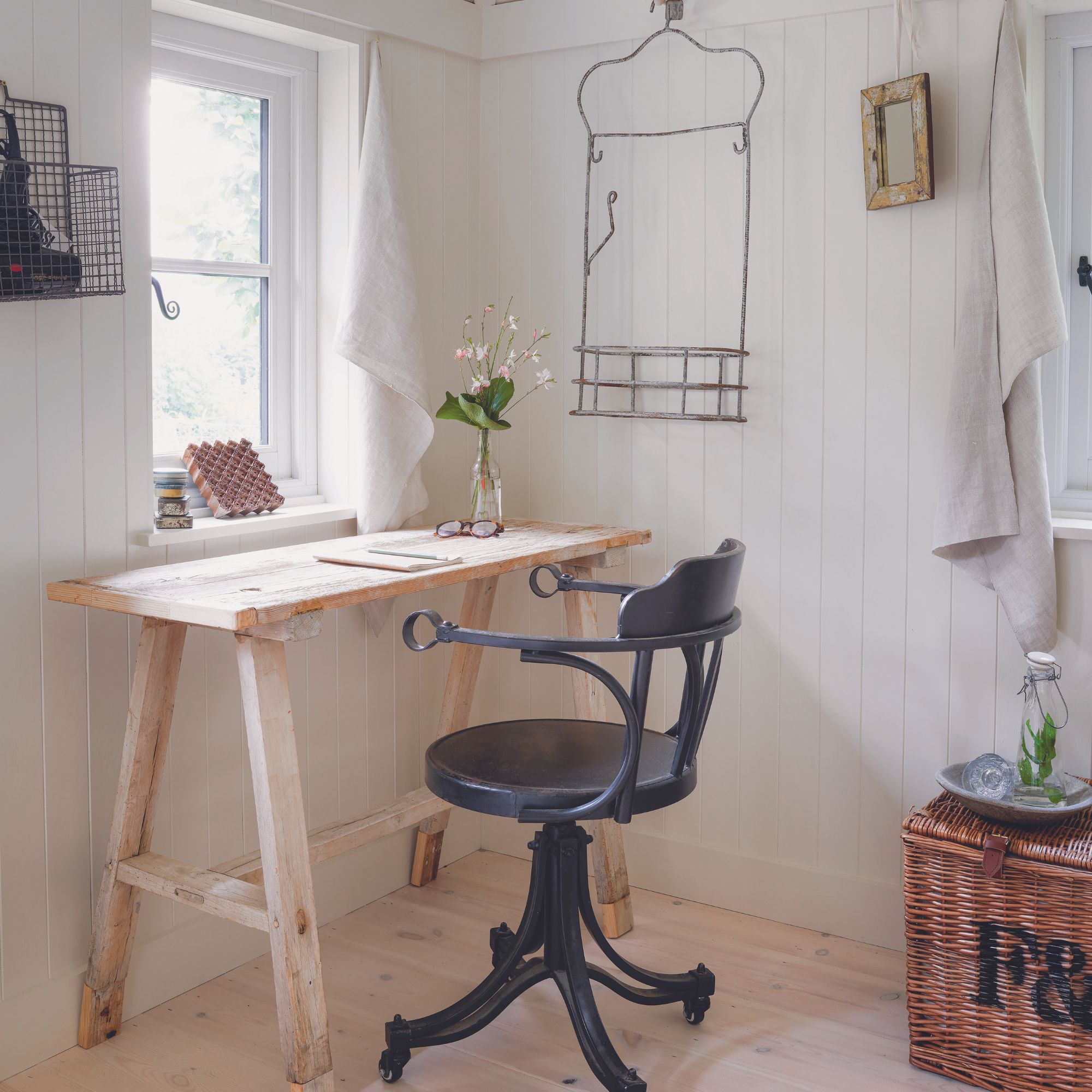 small home office with wooden desk and black chair in country home