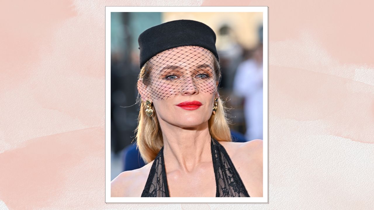 Diane Kruger is pictured with a red lipstick look and wearing a black hat and net veil whilst attending Vogue World: Paris 2024 at the Place Vendome on June 23, 2024 in Paris/ in a pink watercolour paint-style template