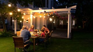 Family dining outside with ambient outside lighting