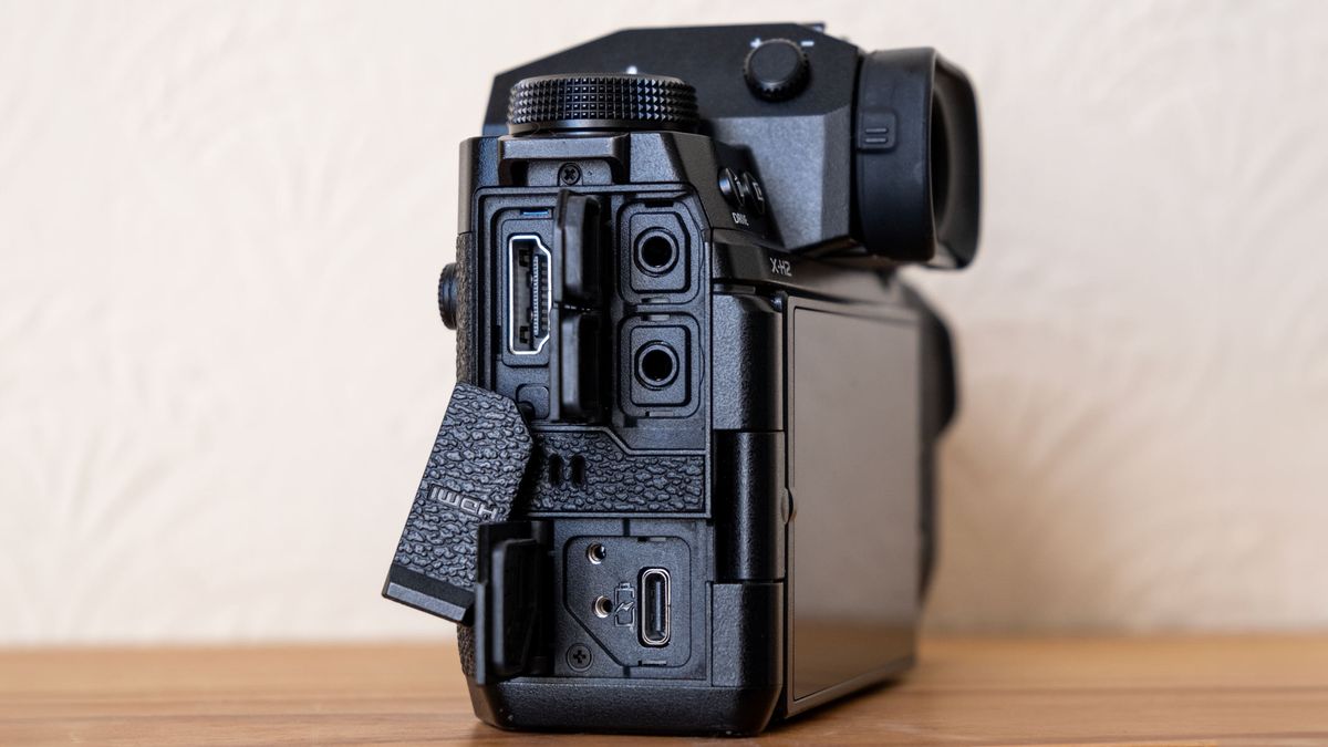 The Fujifilm X-H2 on a wooden shelf with USB-C port, mic jacks and HDMI port on display.
