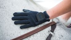 A pair of the best children&rsquo;s riding gloves worn by model on a horse