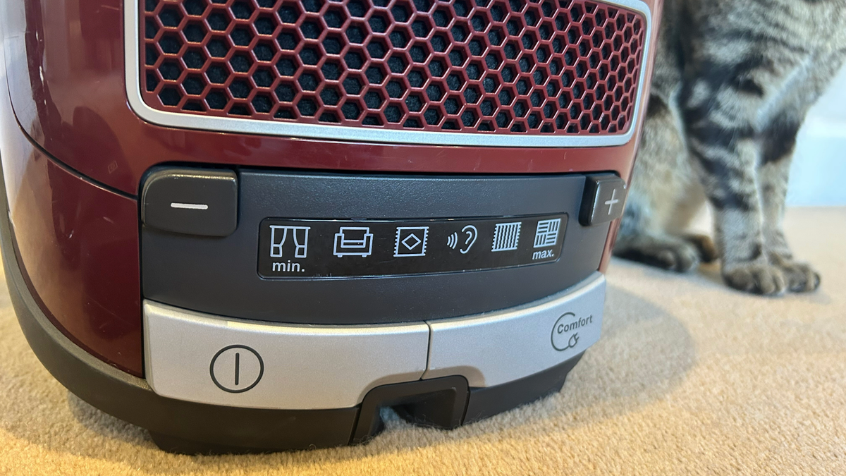 Close-up of the Miele Complete C3 Cat &amp; Dog PowerLine controls, with Megan's cat's paws in the background