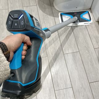Lady cleaning bathroom floor with Bissell SlimSteam mop