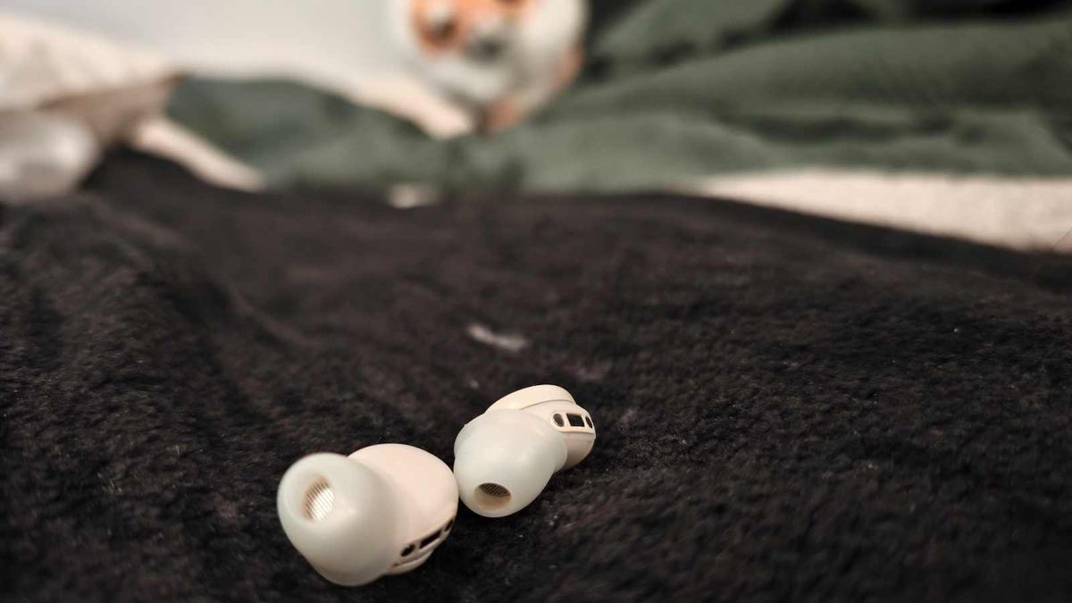 The Fitnexa SomniPods 3 earbuds on a blanket.