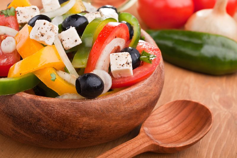 A salad with tomatoes, cheese and black olives