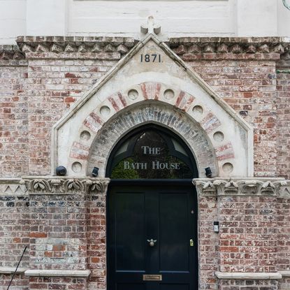 bath house made of brick and bumble bee door