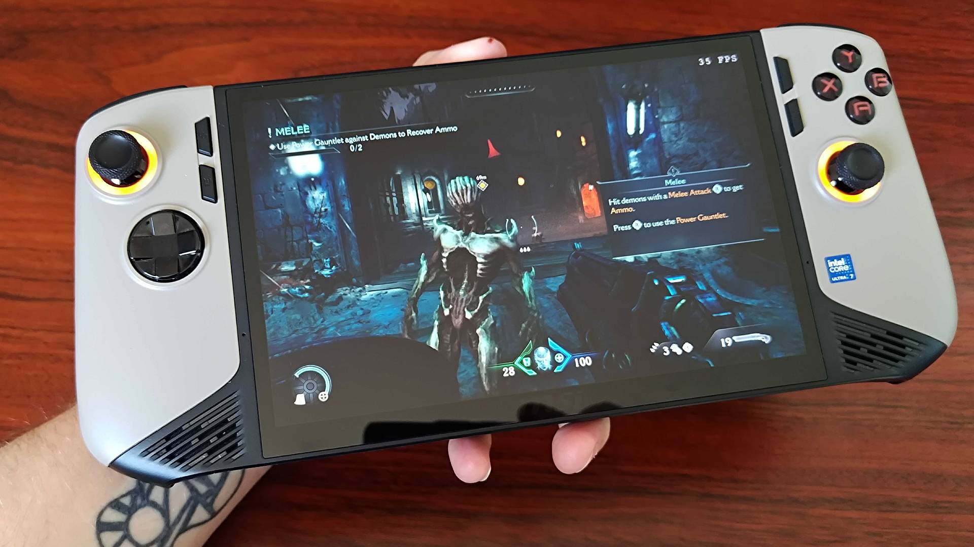 MSI Claw 8 AI+ with DOOM: The Dark Ages gameplay on screen featuring enemy and Doomslayer standing with shotgun.
