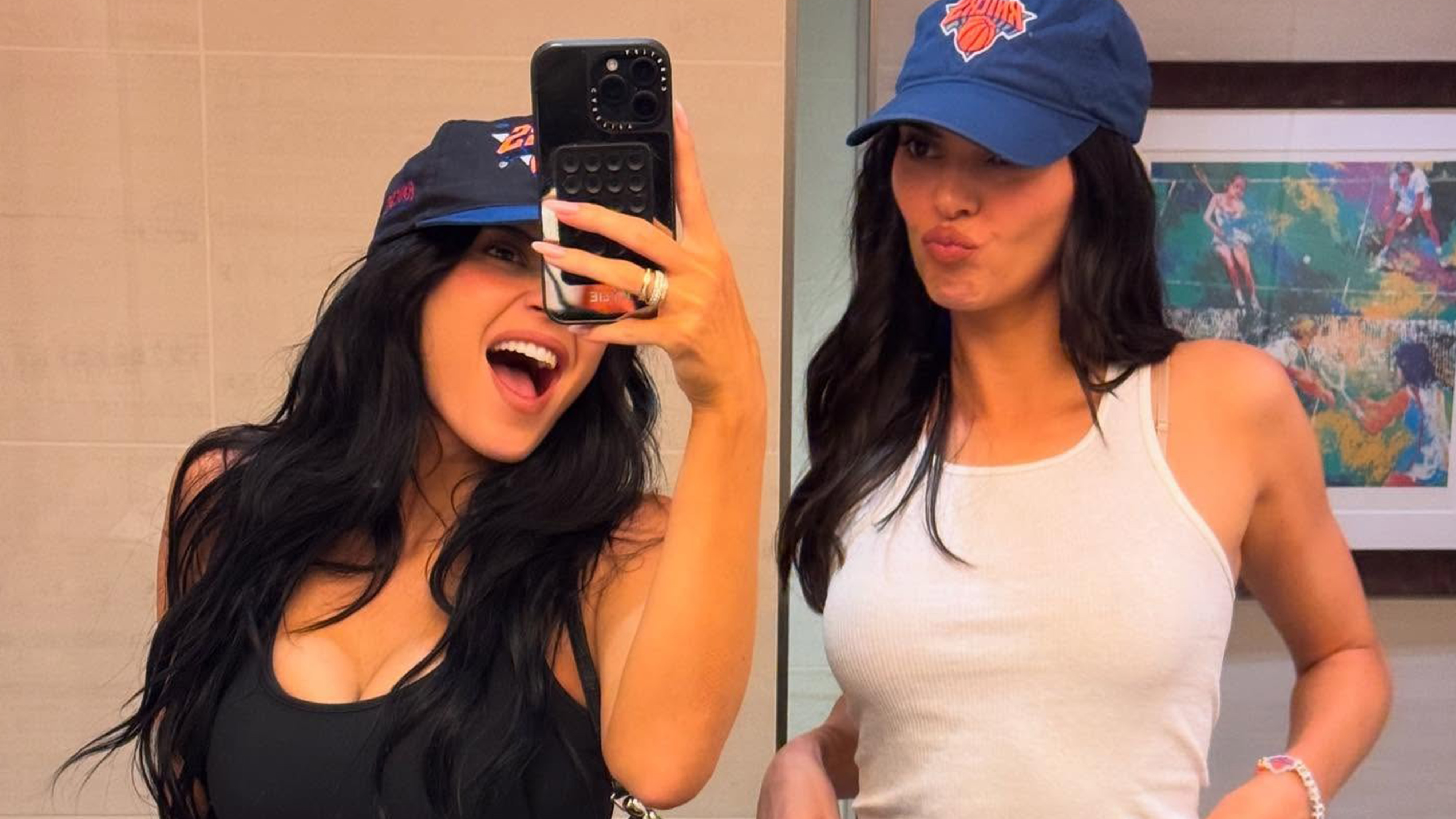 Kylie and kendall jenner wear knicks hats with tank tops and leather pants.