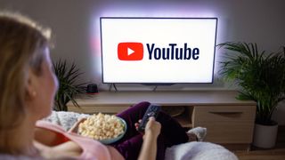 A person watching YouTube on a television with popcorn