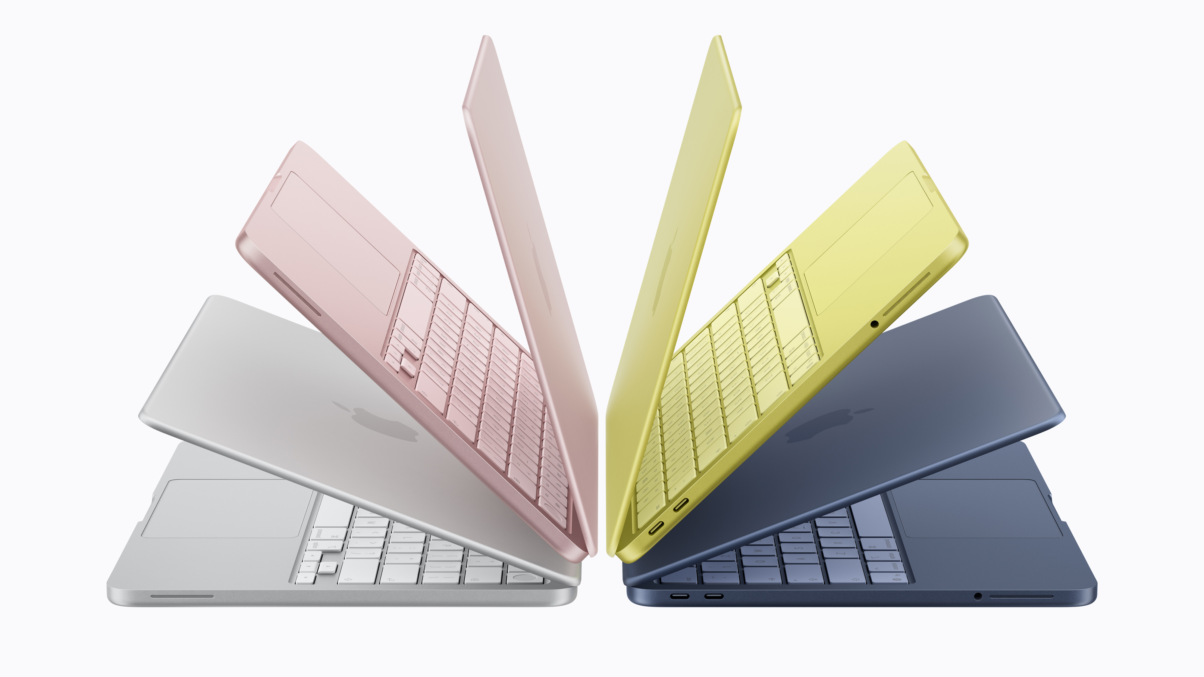 Apple MacBook Neo laptops shown in four colors including silver, pink, yellow and blue arranged in an open fan formation.