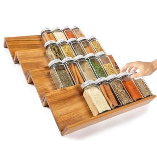 A wooden spice organizer with four tiers