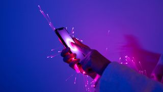 Close-up of holding smartphone, arms wrapped with pink fiber optics