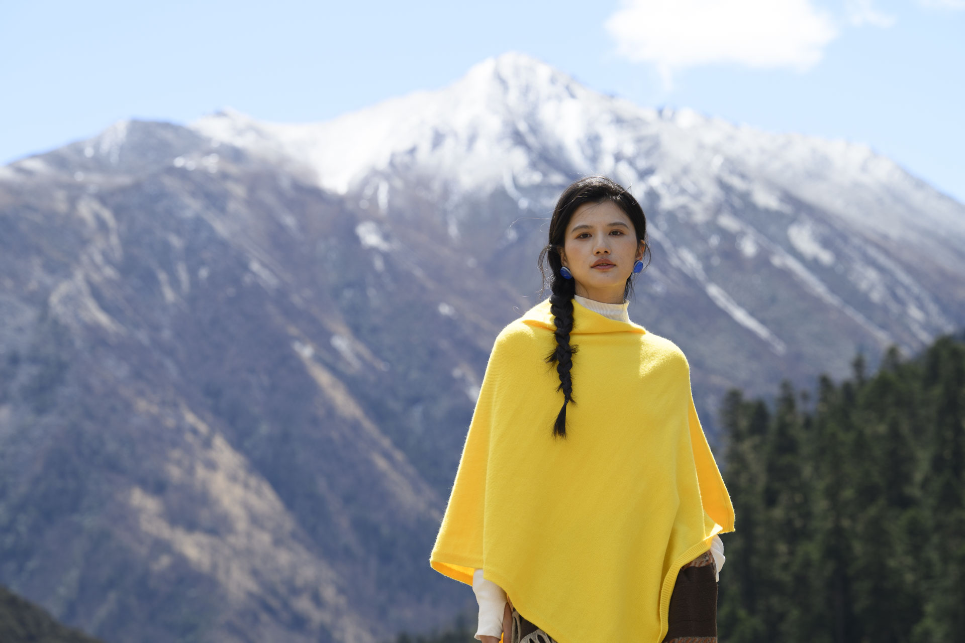 Nikon Z 70-200mm f/2.8 VR S II image gallery: female model in a yellow shawl in front of snow-covered mountains