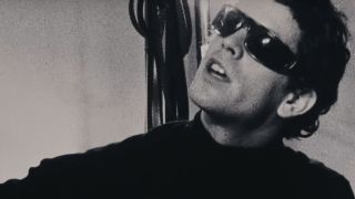 Lou Reed wearing sunglasses in a black and white screenshot.