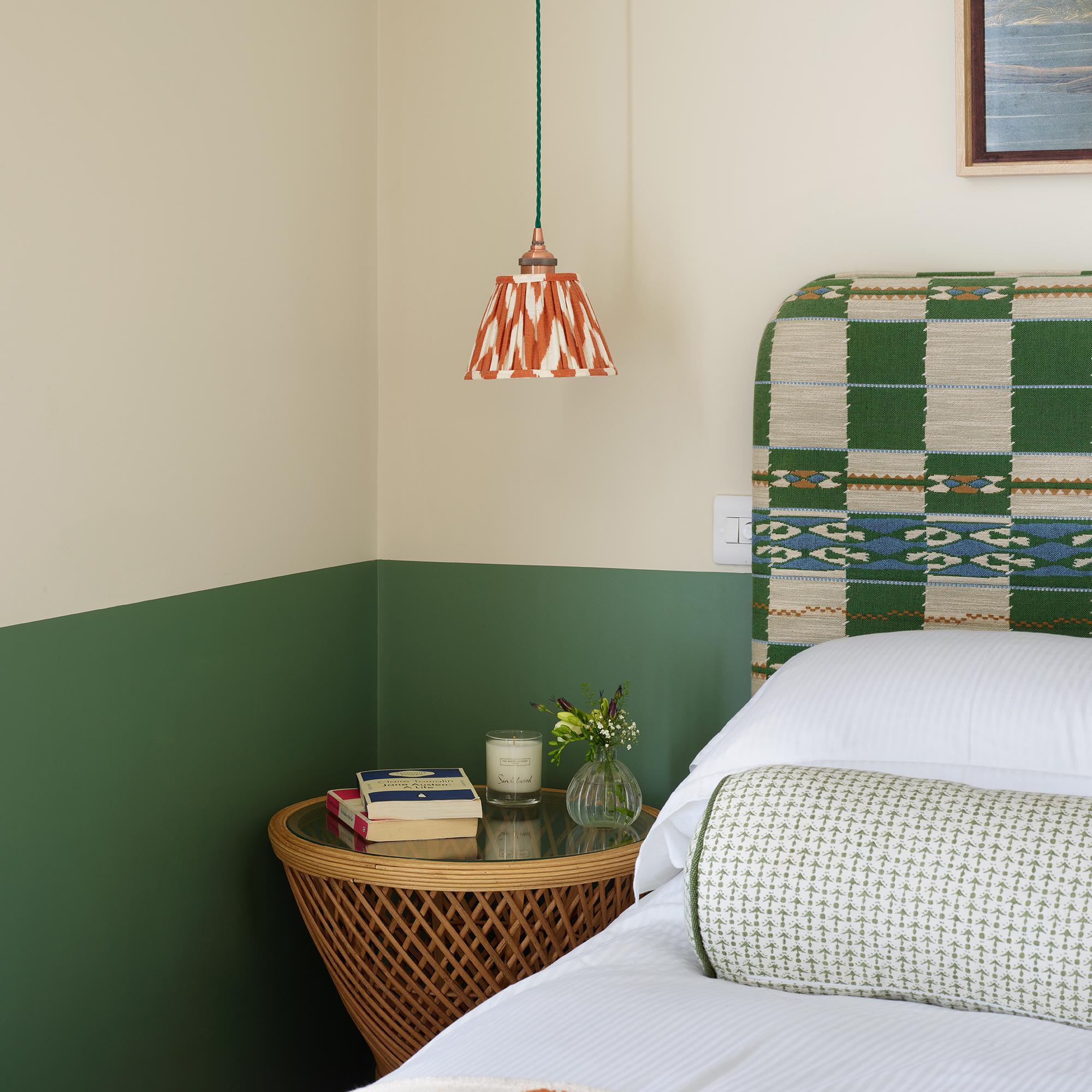 Corner of bedroom with walls painted half cream, half green