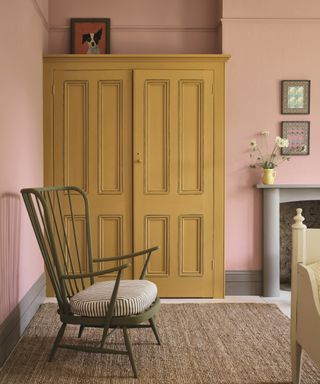colors not to paint your furniture, pale pink bedroom with yellow painted wardrobe, white flooring, rug, green painted chair, artwork