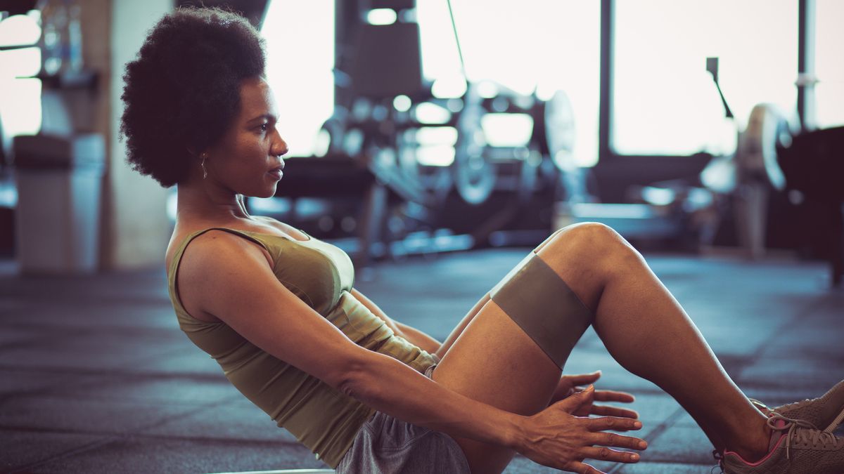 Woman performing abs exercise in gym