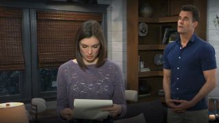 Katelyn MacMullen as Willow reading paperwork and Cameron Mathison as Drew watching in General Hospital