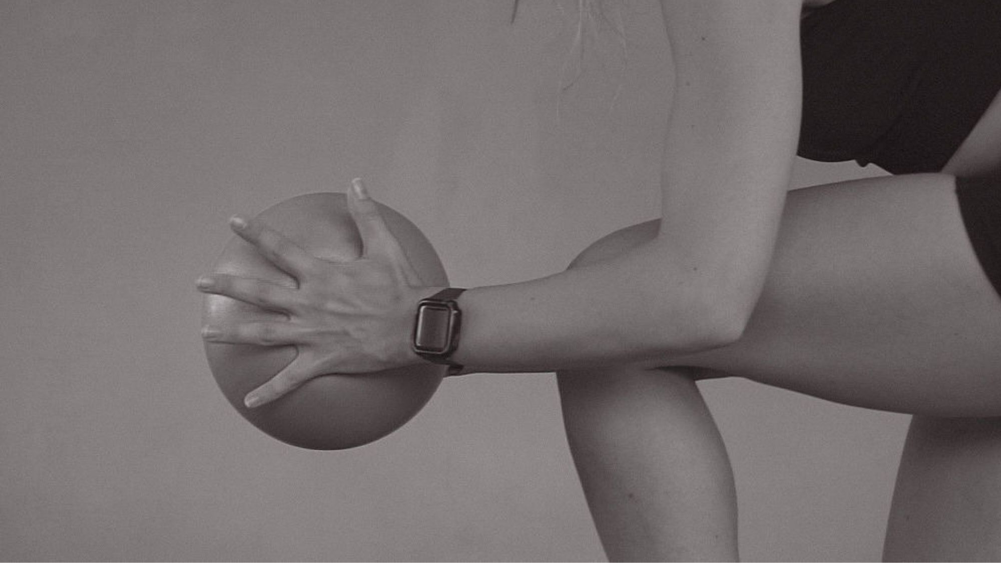 A woman holding a Pilates ball during a workout