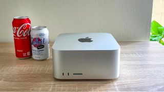 Mac Studio on desk next to drink cans for scale