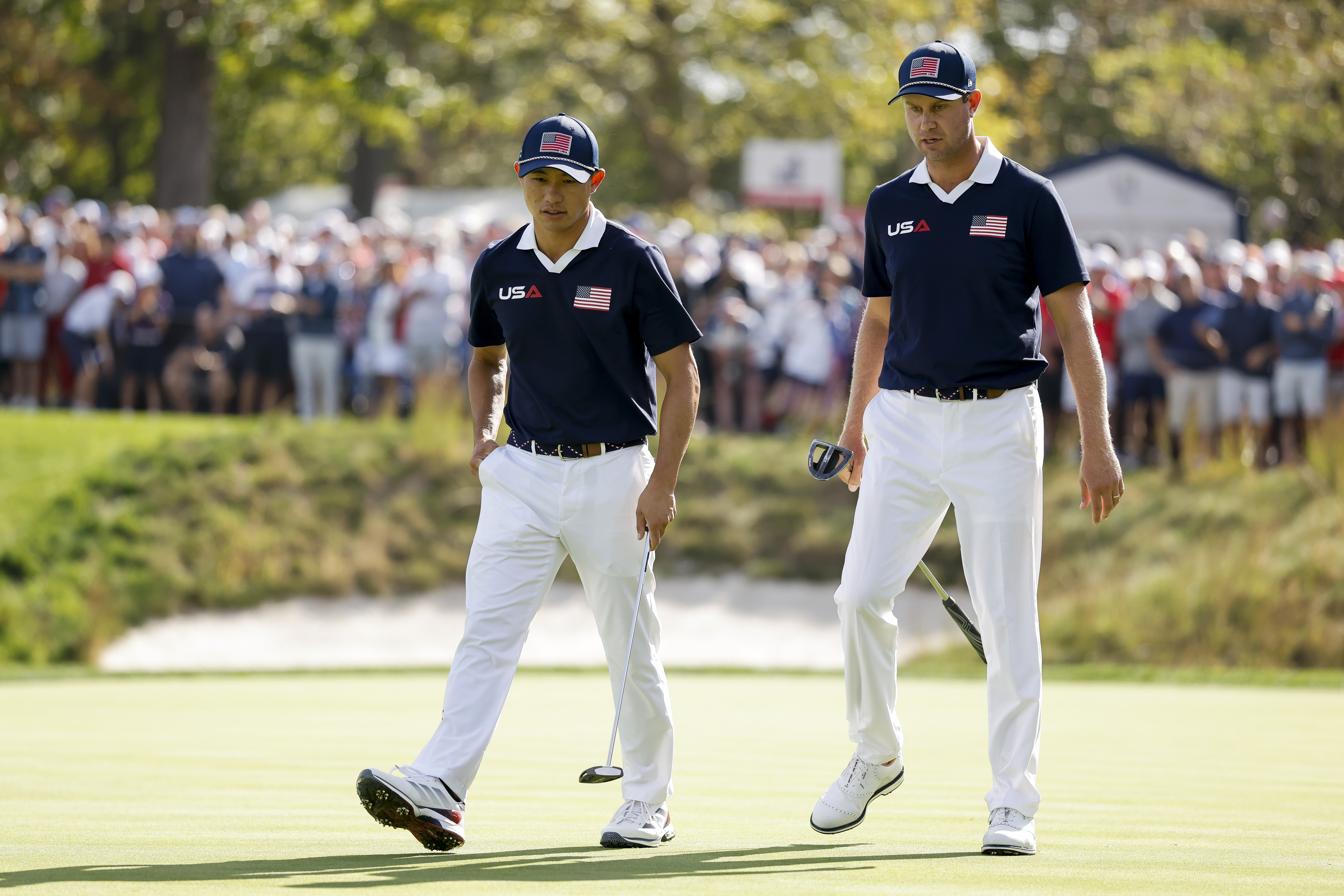 Collin Morikawa and Harris English walk on the green at the 2025 Ryder Cup