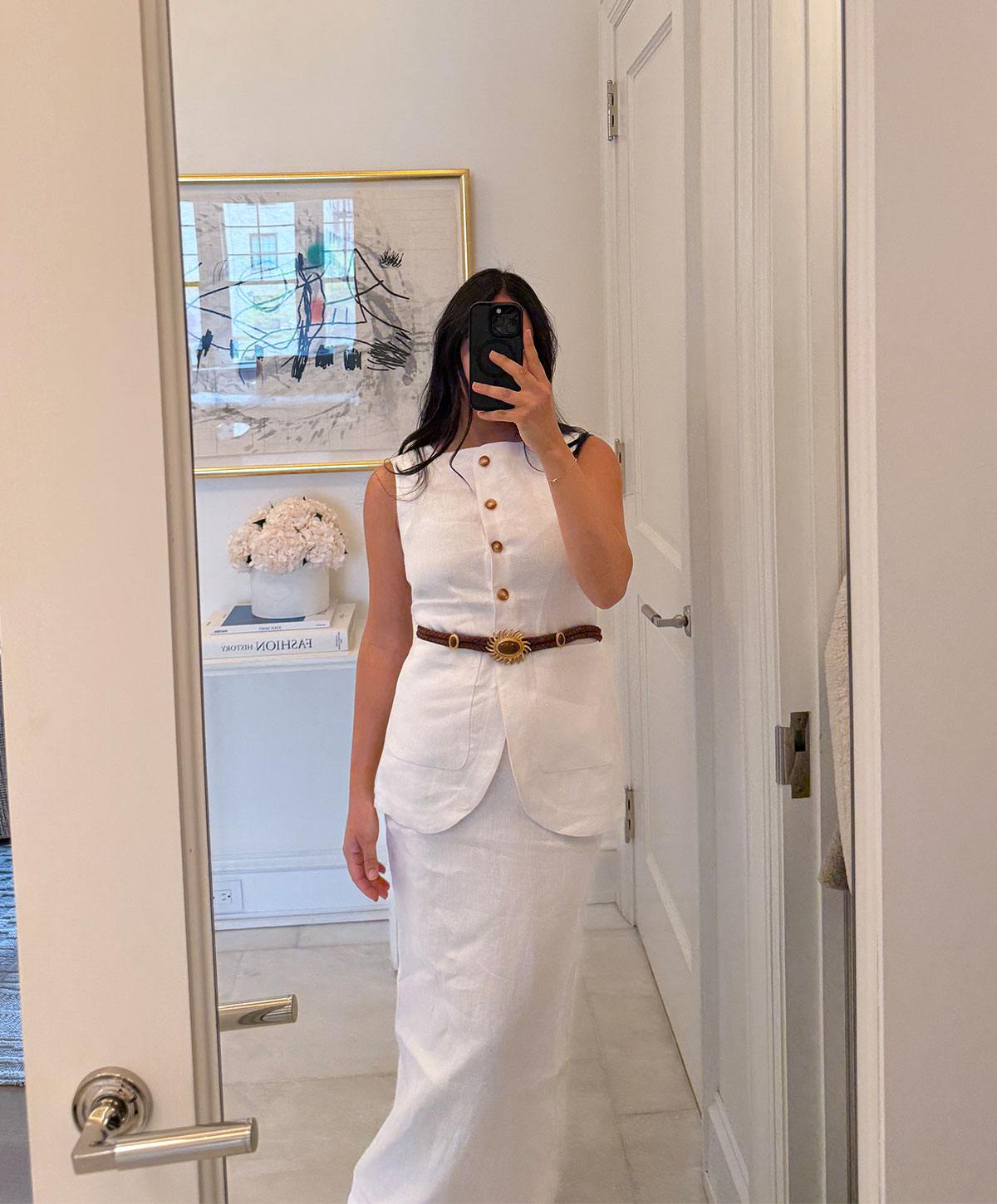 @nicoleakhtarzad taking a mirror outfit selfie and wearing a Posse matching white linen set with belt.