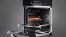 A lifestyle image of the Miele oven with an open door and a pie going in on a shelf